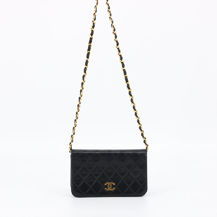 Chanel Black Quilted Lambskin bag, photographed against soft cream backdrop