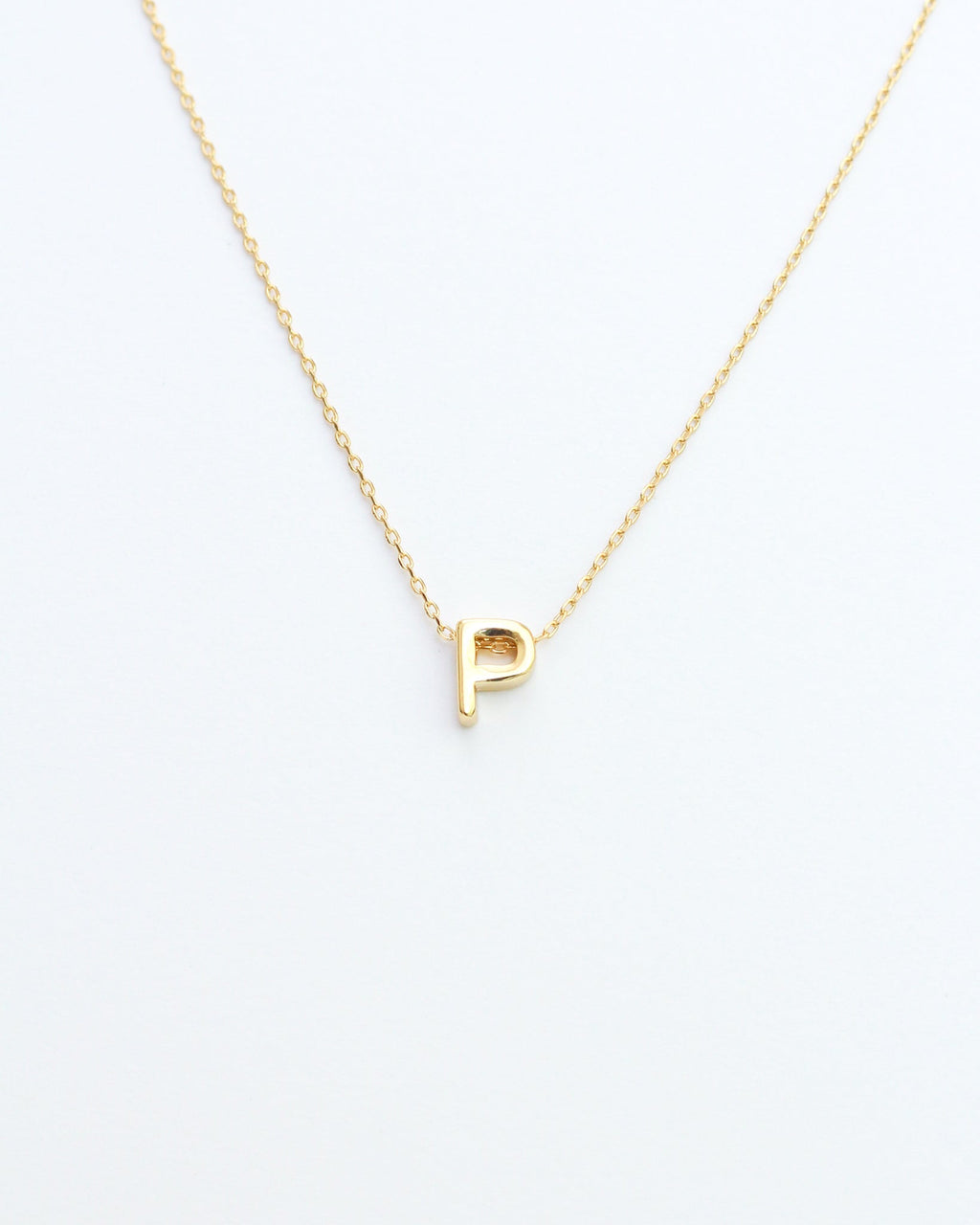 KADOU BOUTIQUE Gold Block Letter Initial Necklace — flat-lay composition