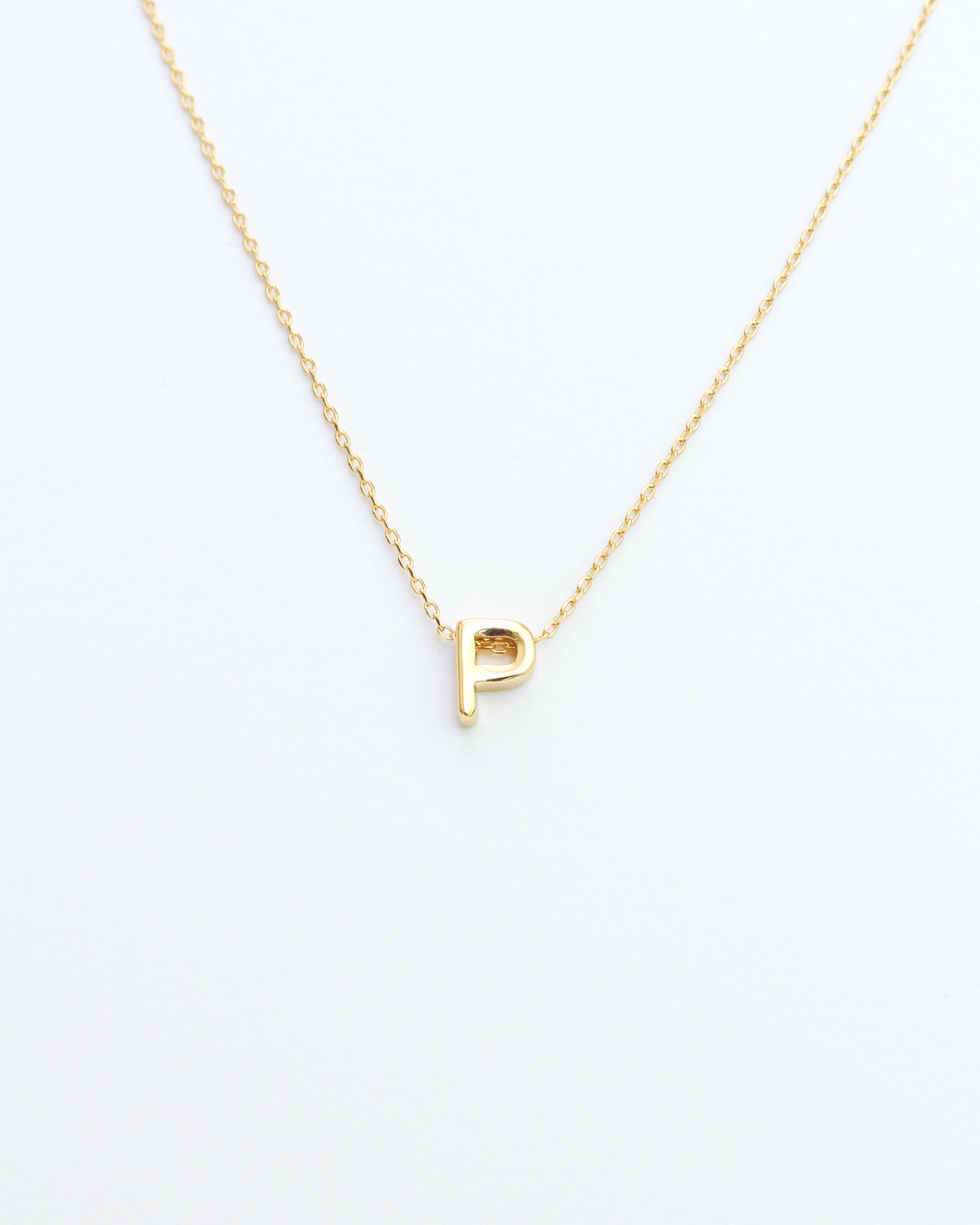 KADOU BOUTIQUE Gold Block Letter Initial Necklace — flat-lay composition