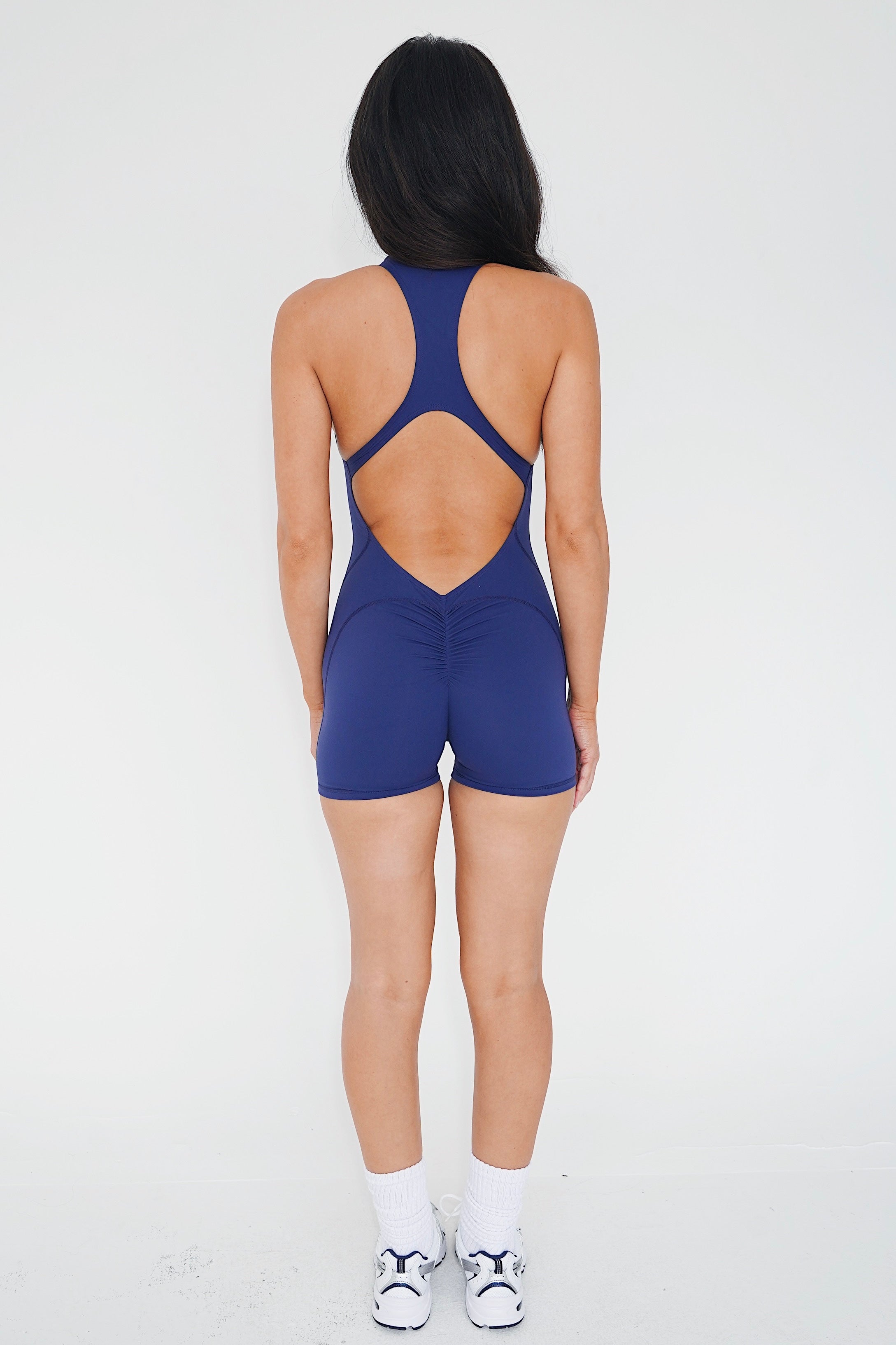 KIMITH BRAND I am Limitless Zipper Bodysuit in Navy — lifestyle worn / used context