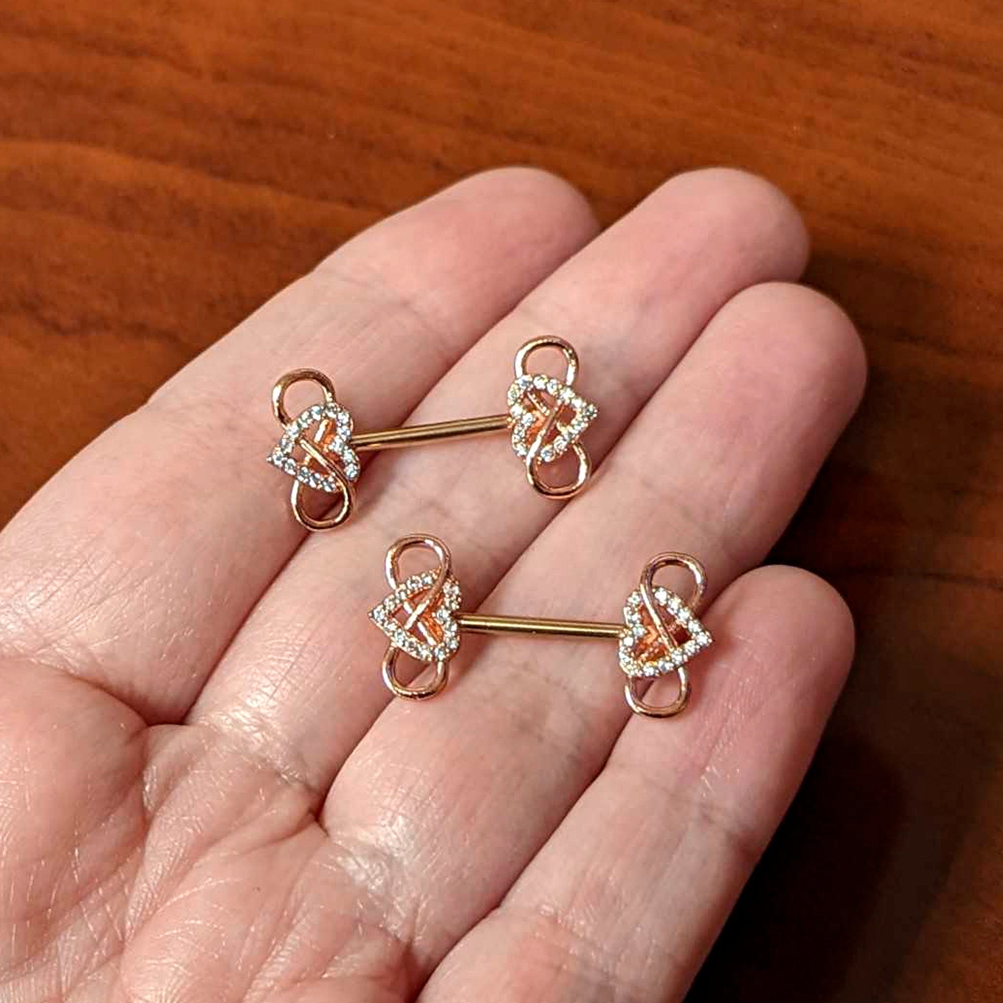 BodyCandy 14G 1/2 Clear CZ Gem Rose Gold Hue Infinity Heart Nipple Ring Set — side view