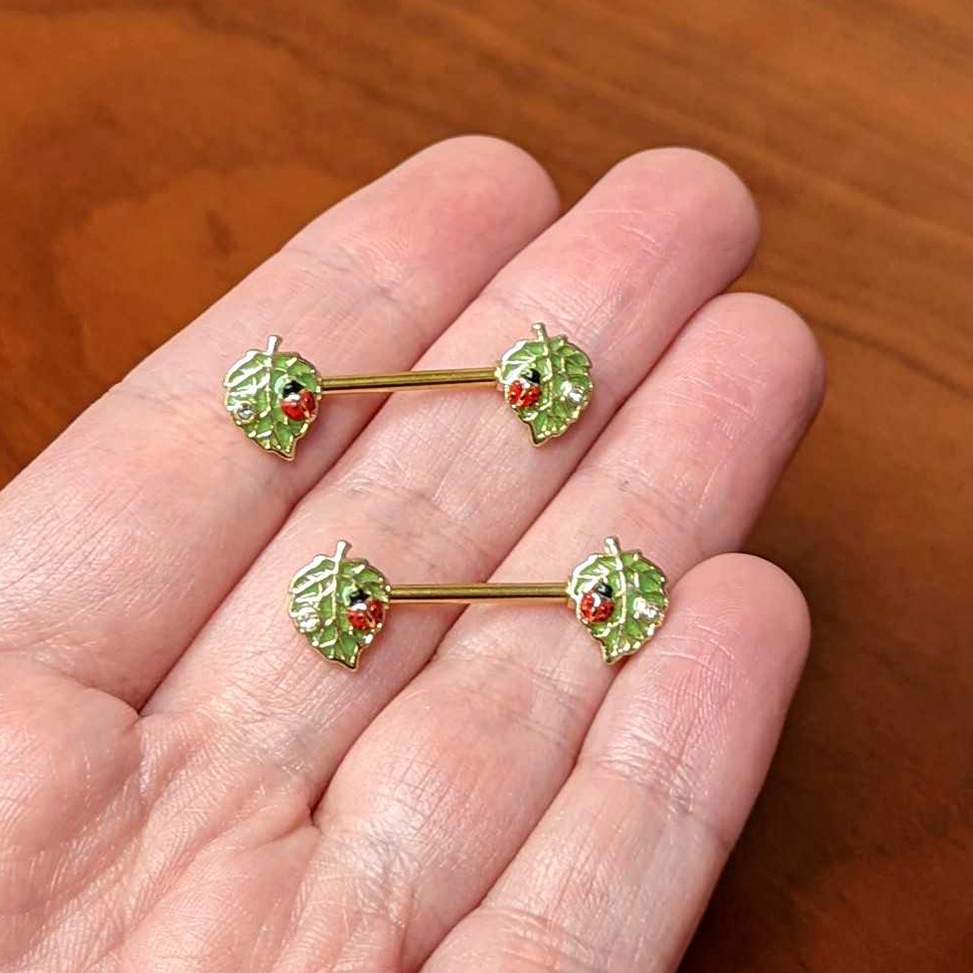 BodyCandy 14G 9/16 Clear Gem Gold Hue Leafy Ladybug Barbell Nipple Ring Set — side view