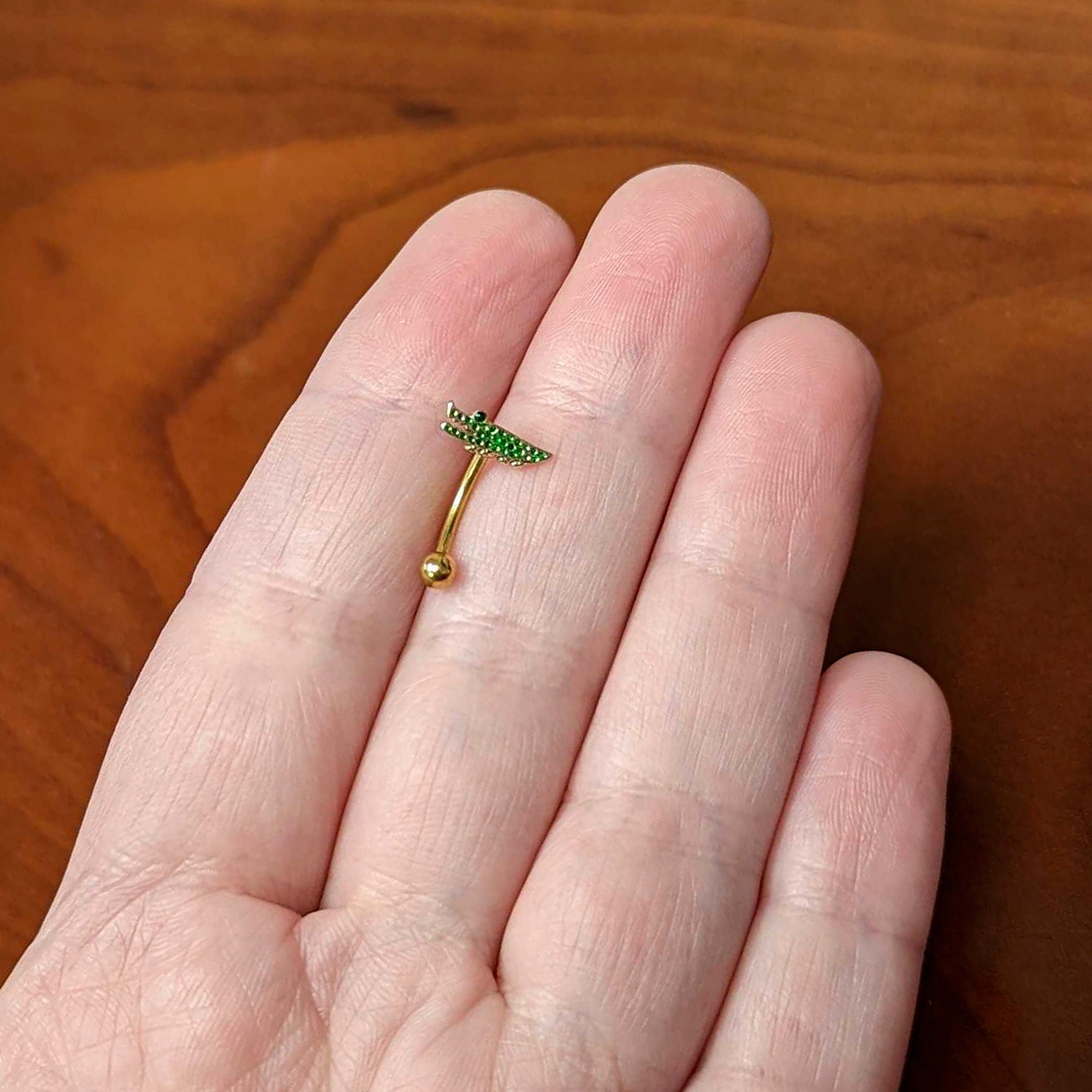 BodyCandy 16G 5/16 Green Gem Gold Tone Hungry Alligator Curved Eyebrow Ring — lifestyle context