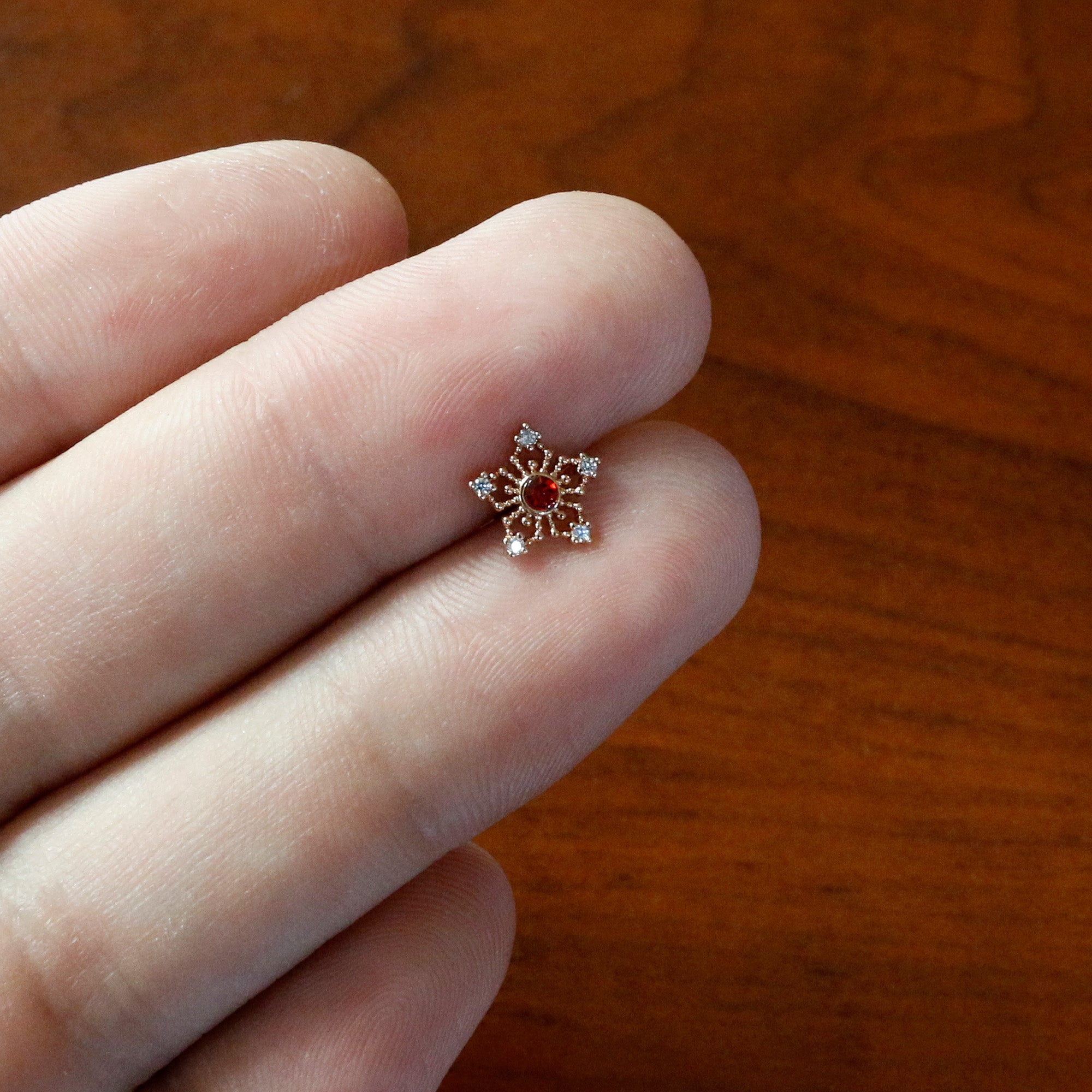 BodyCandy 16G 1/4 Red Gem Rose Gold Tone Texture Snowflake Labret Tragus — in-use photo