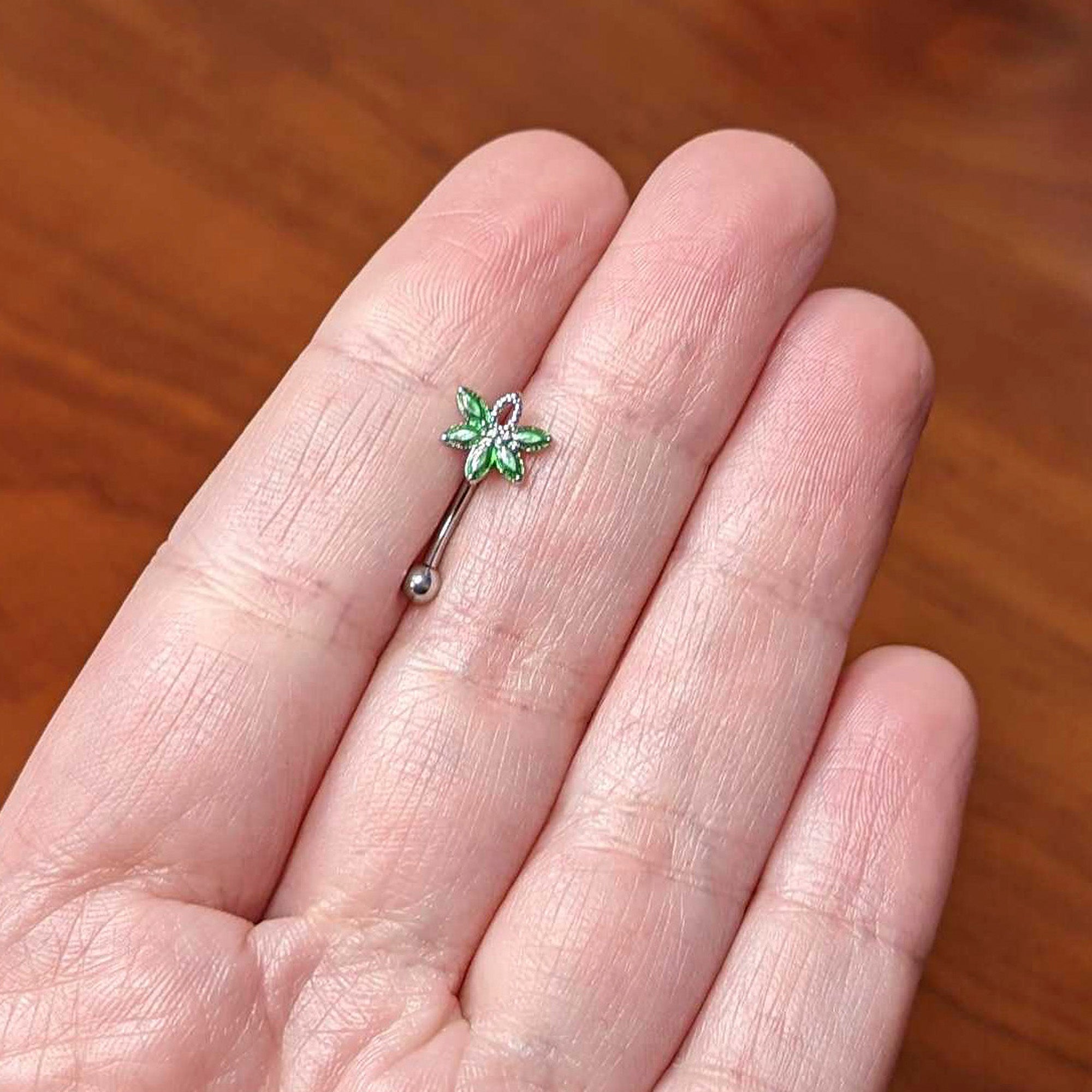 BodyCandy 16G 5/16 Green Gem Pot Leaf Textured Curved Eyebrow Ring — lifestyle context