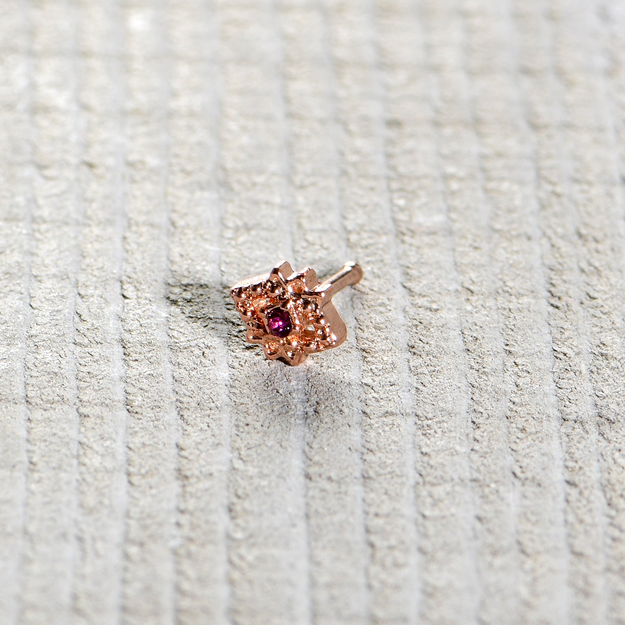 BodyCandy 20G 1/4 Red Gem Rose Gold Tone Octogram Star Nose Bone — in-use photo