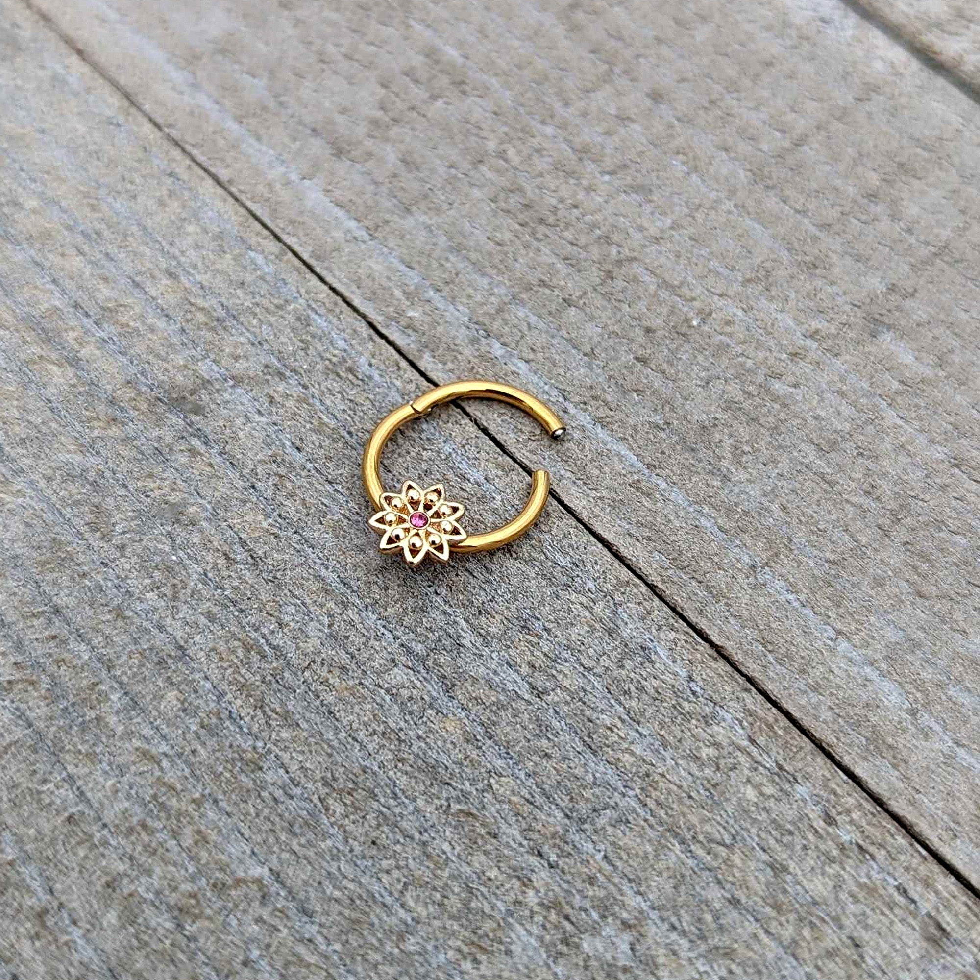 BodyCandy 16G 3/8 Pink Gem Gold Tone Starry Flower Hinged Segment Ring — in-use photo