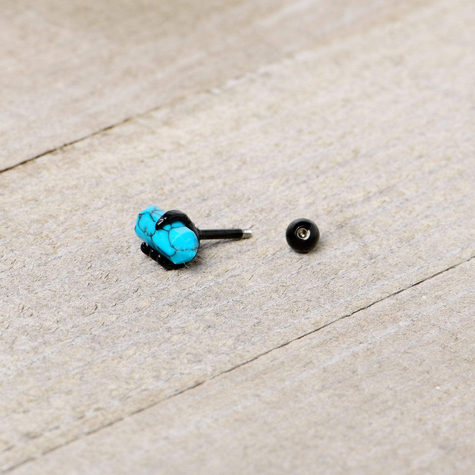 BodyCandy 16G 1/4 Blue Turquoise Black Claw Obelisk Cartilage Earring — in-use photo