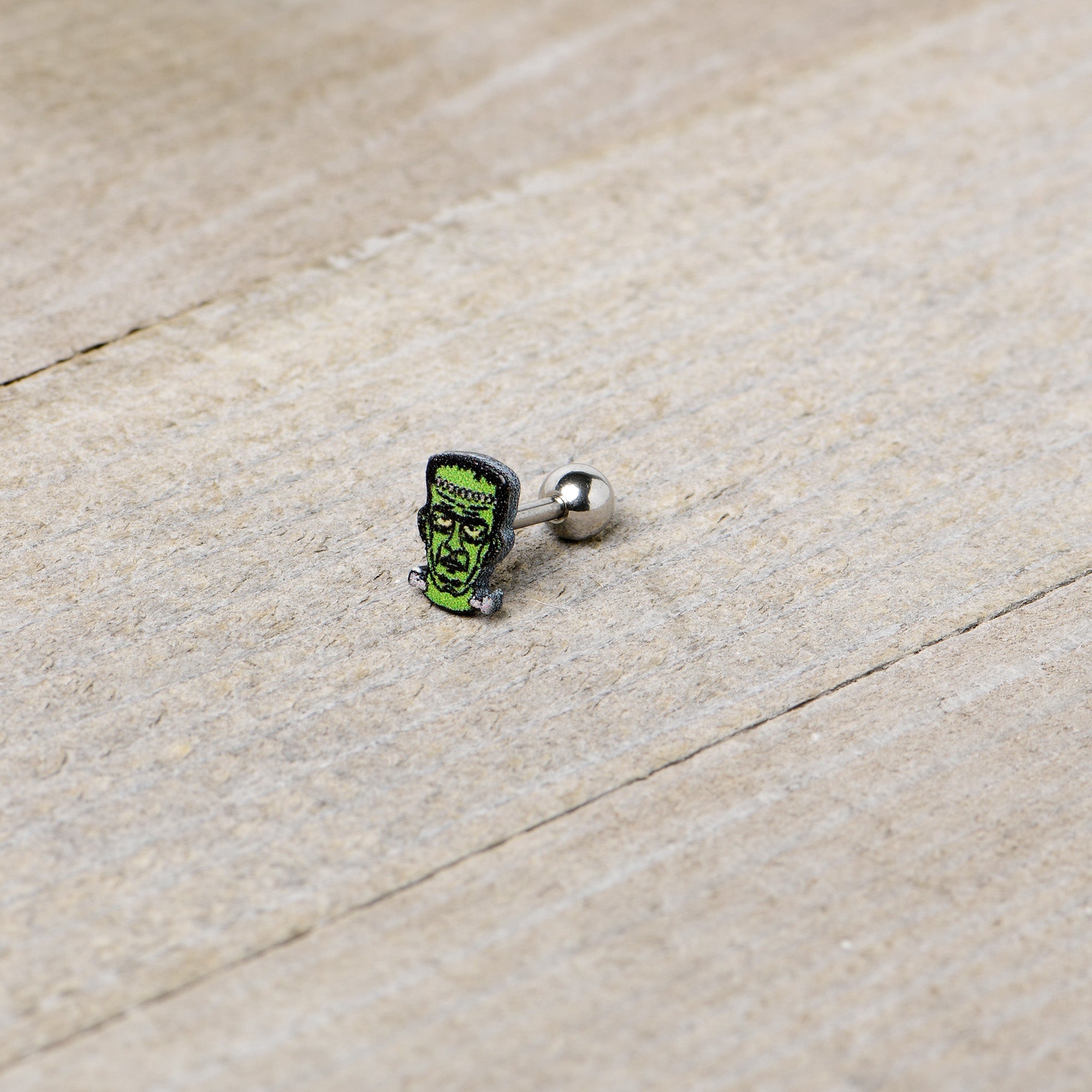 BodyCandy 16G 1/4 Frankenstein Head Green Glow in the Dark Cartilage Earring — in-use photo