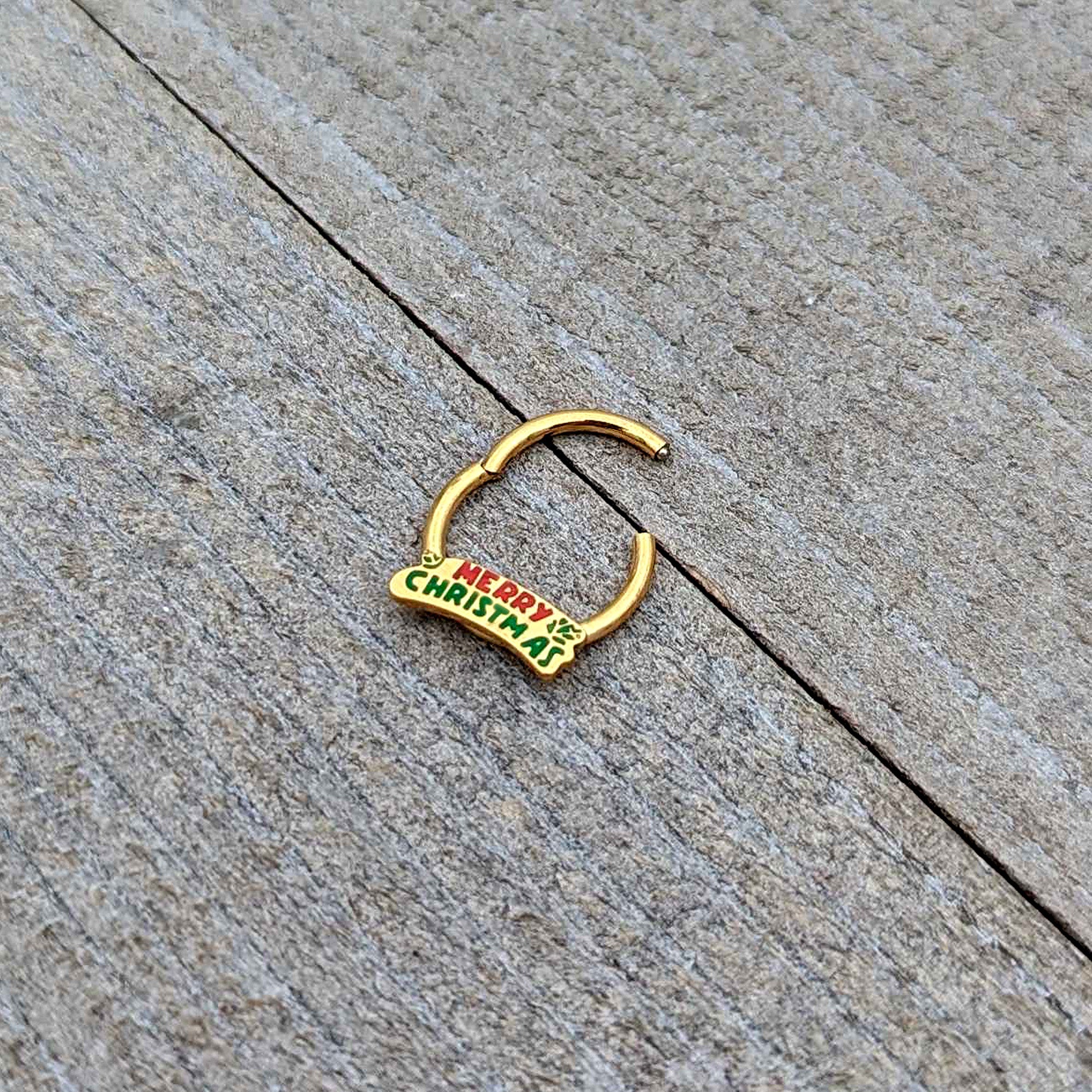 BodyCandy 16G 3/8 Gold Tone Merry Christmas Inlay Hinged Segment Ring — in-use photo