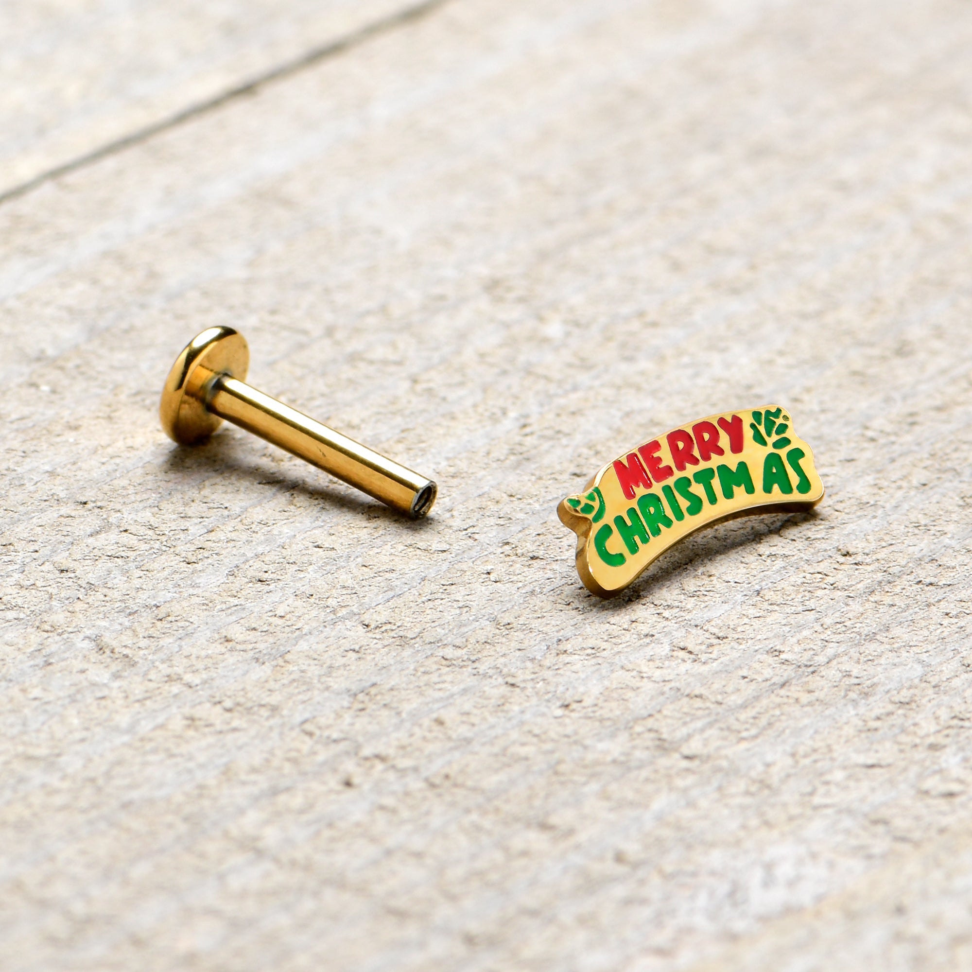 BodyCandy 16G 5/16 Gold Tone Merry Christmas Inlaid Labret Monroe Tragus — in-use photo