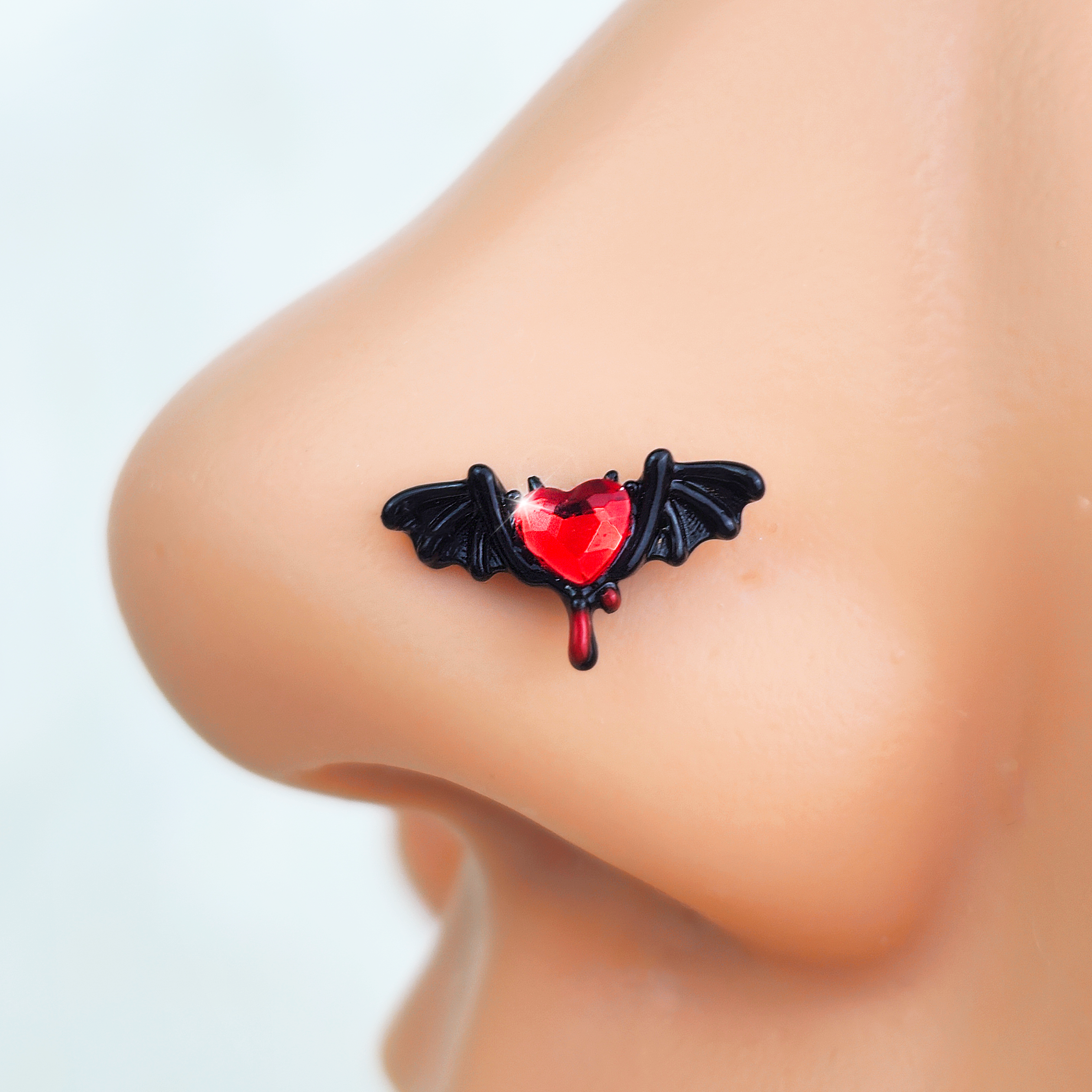 BodyCandy 20G 7mm Red Gem Black Bleeding Heart Bat Left Side Nose Screw — detail close-up