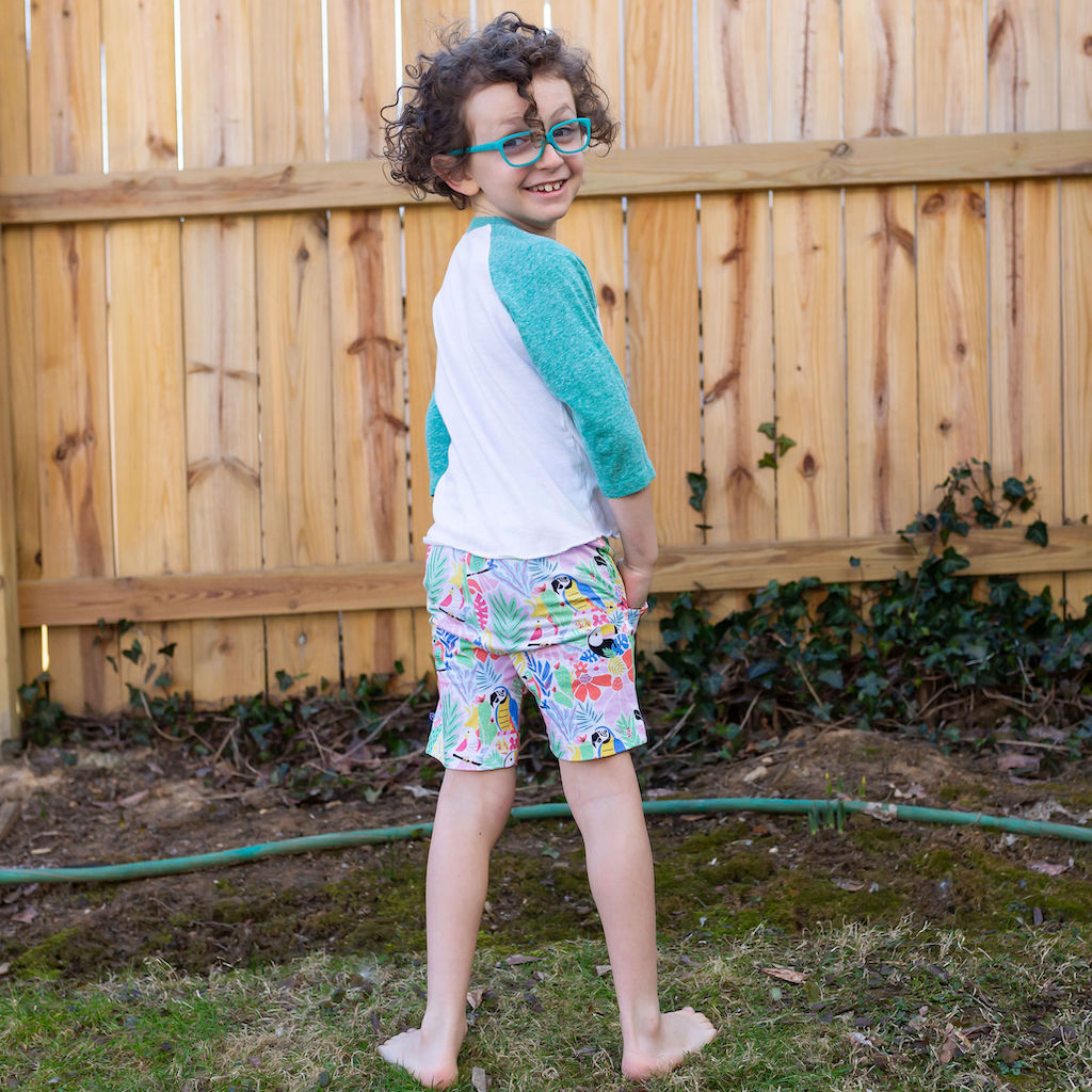 Princess Awesome & Boy Wonder "Jungle Jam" Tropical Birds Drawstring Shorts with Pockets — Princess Awesome & Boy Wonder branding close-up