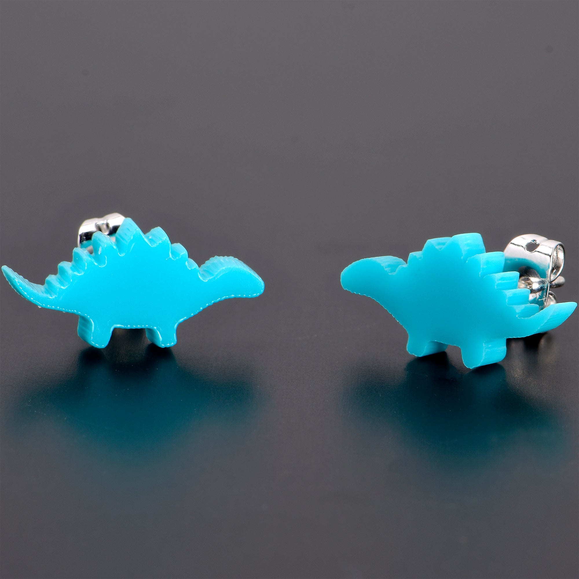 BodyCandy Blue Acrylic Stegosaurus Dinosaur Stud Earrings — in-use photo