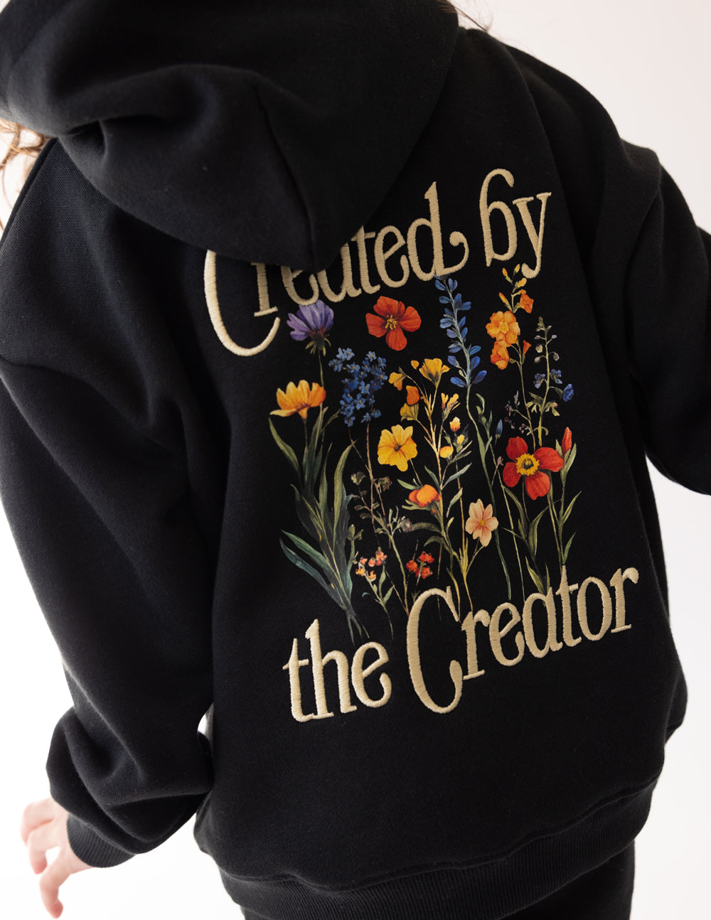 Elevated Faith Created by the Creator Kids Hoodie — Elevated Faith branding close-up