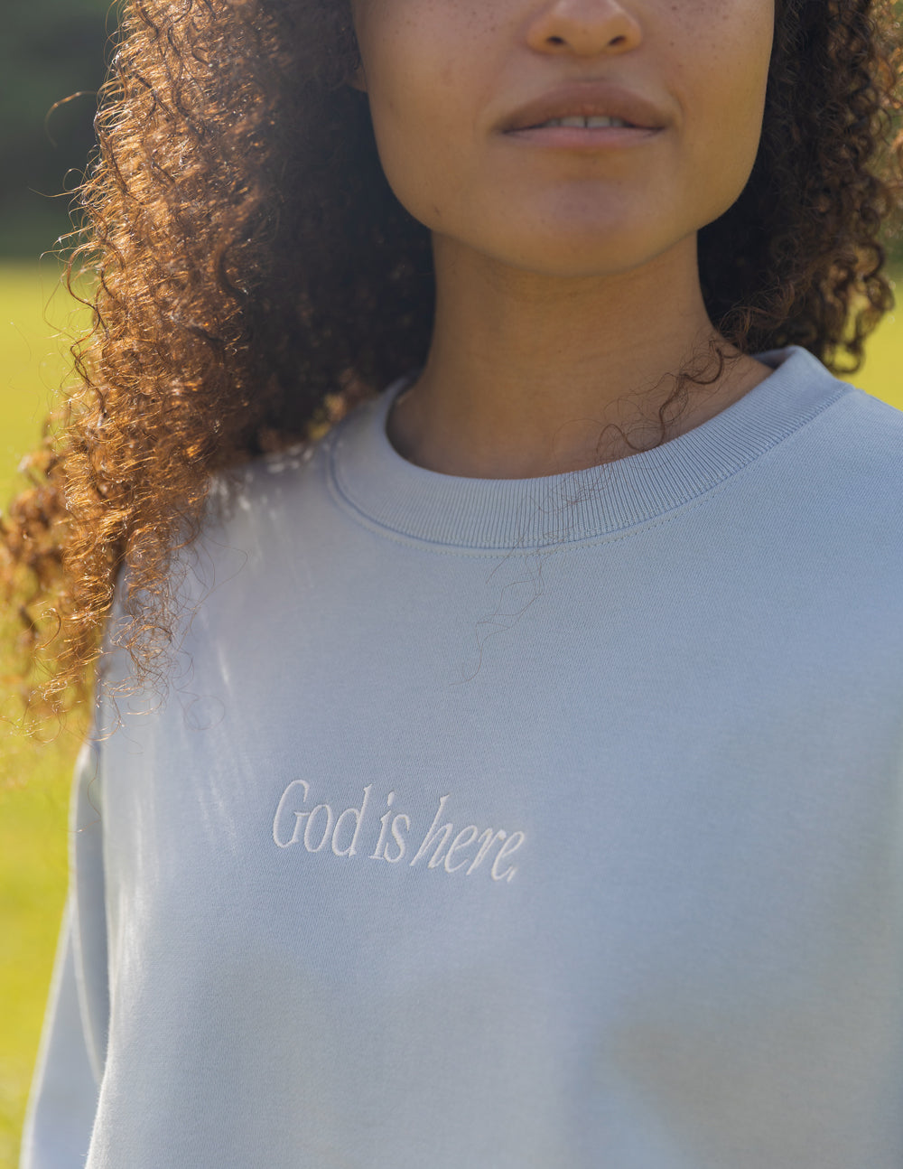 Elevated Faith God Is Here Unisex Crewneck — Elevated Faith branding close-up