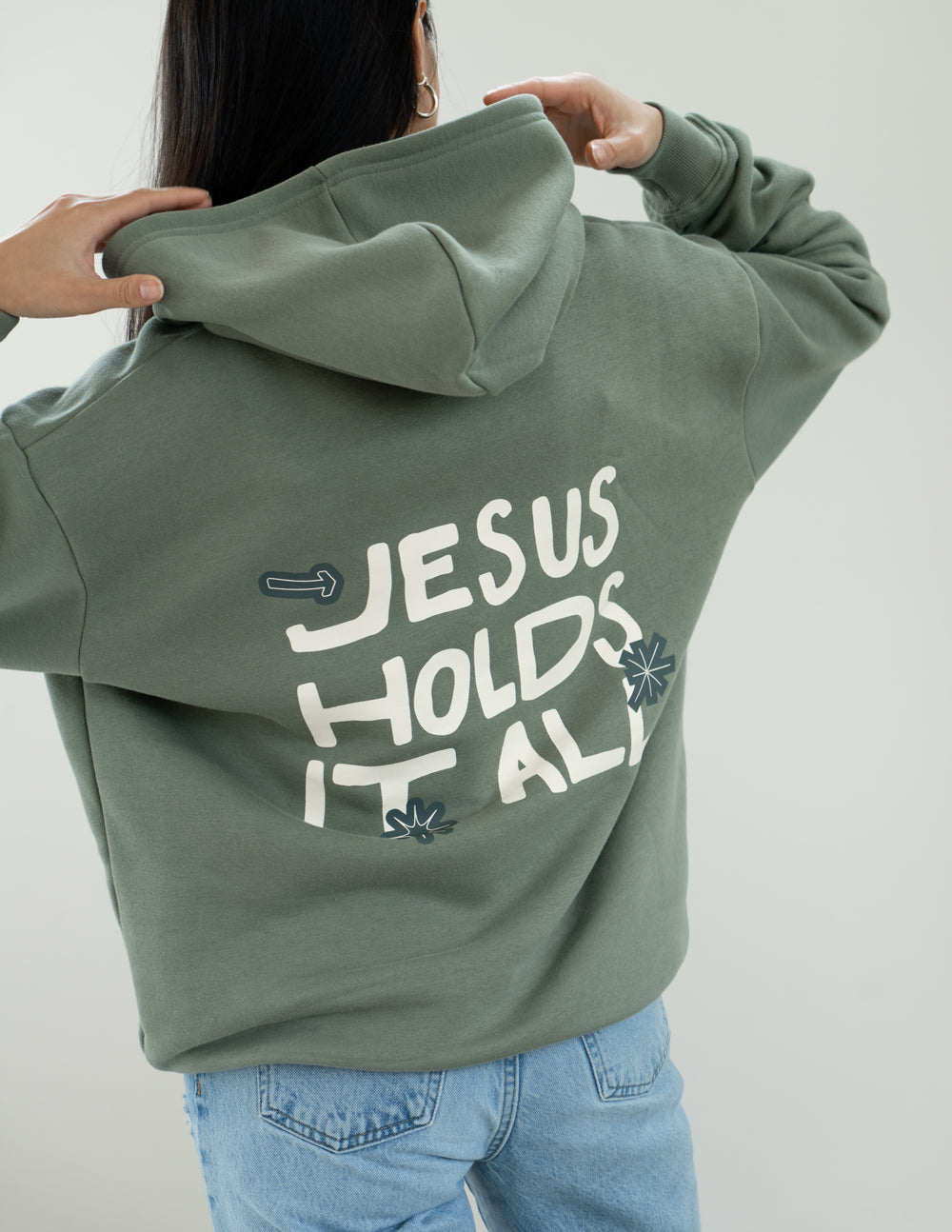 Elevated Faith Jesus Holds It All Unisex Hoodie — Elevated Faith branding close-up