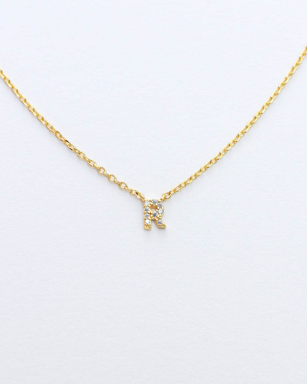 KADOU BOUTIQUE Mini Pave Initial Necklace — flat-lay composition