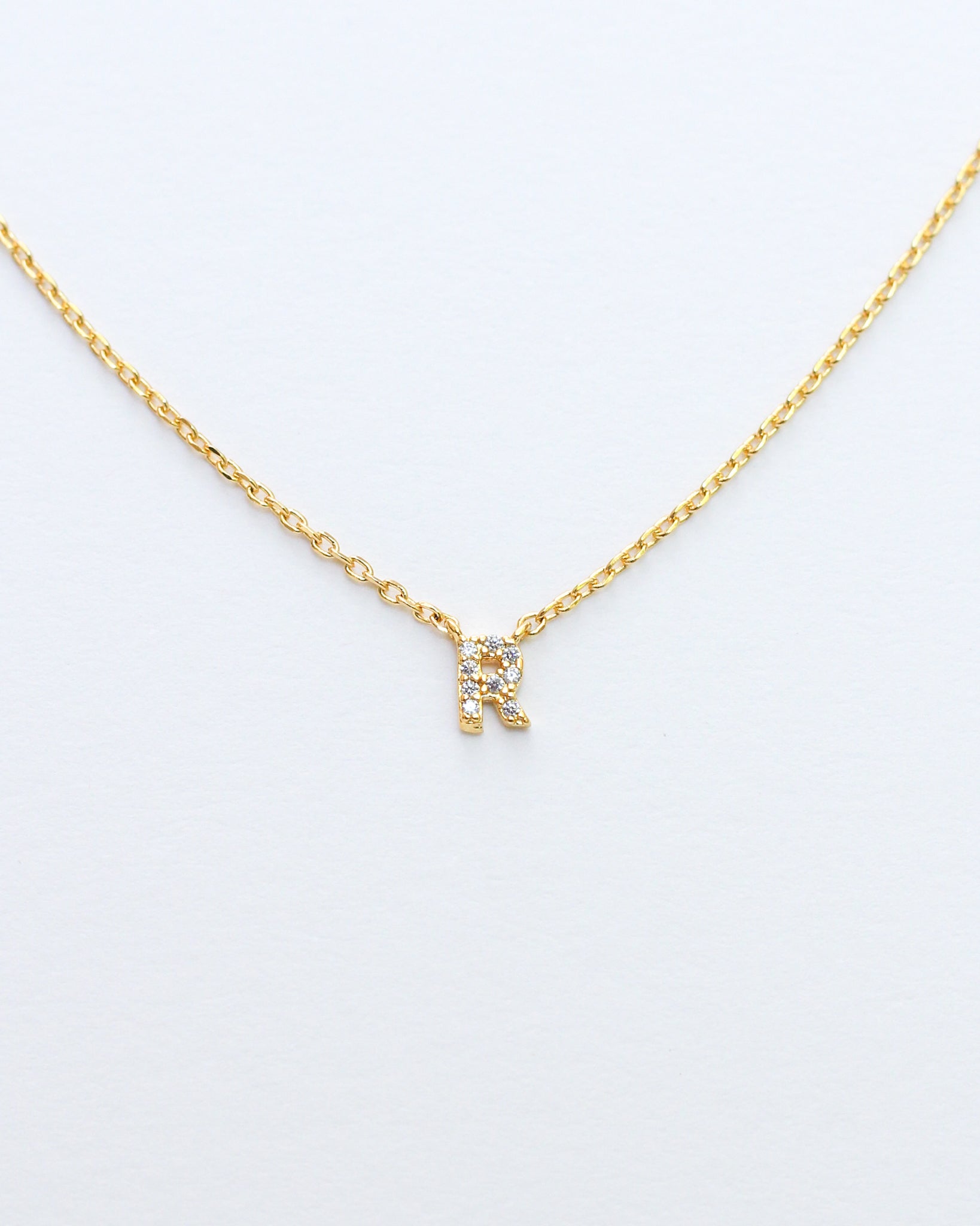 KADOU BOUTIQUE Mini Pave Initial Necklace — flat-lay composition