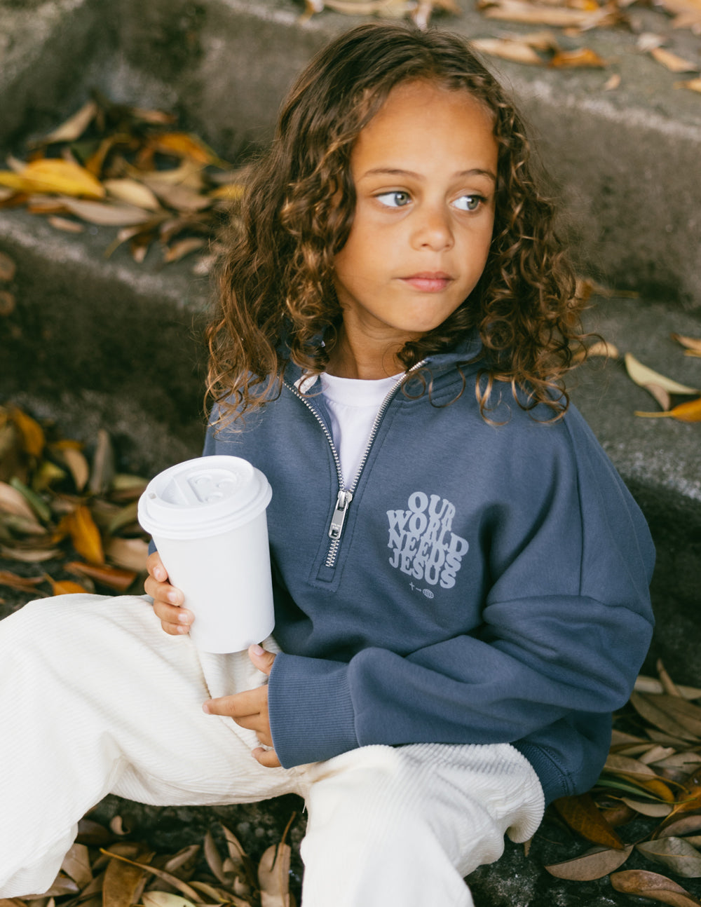 Elevated Faith Our World Needs Jesus Kids Half-Zip — Elevated Faith branding close-up