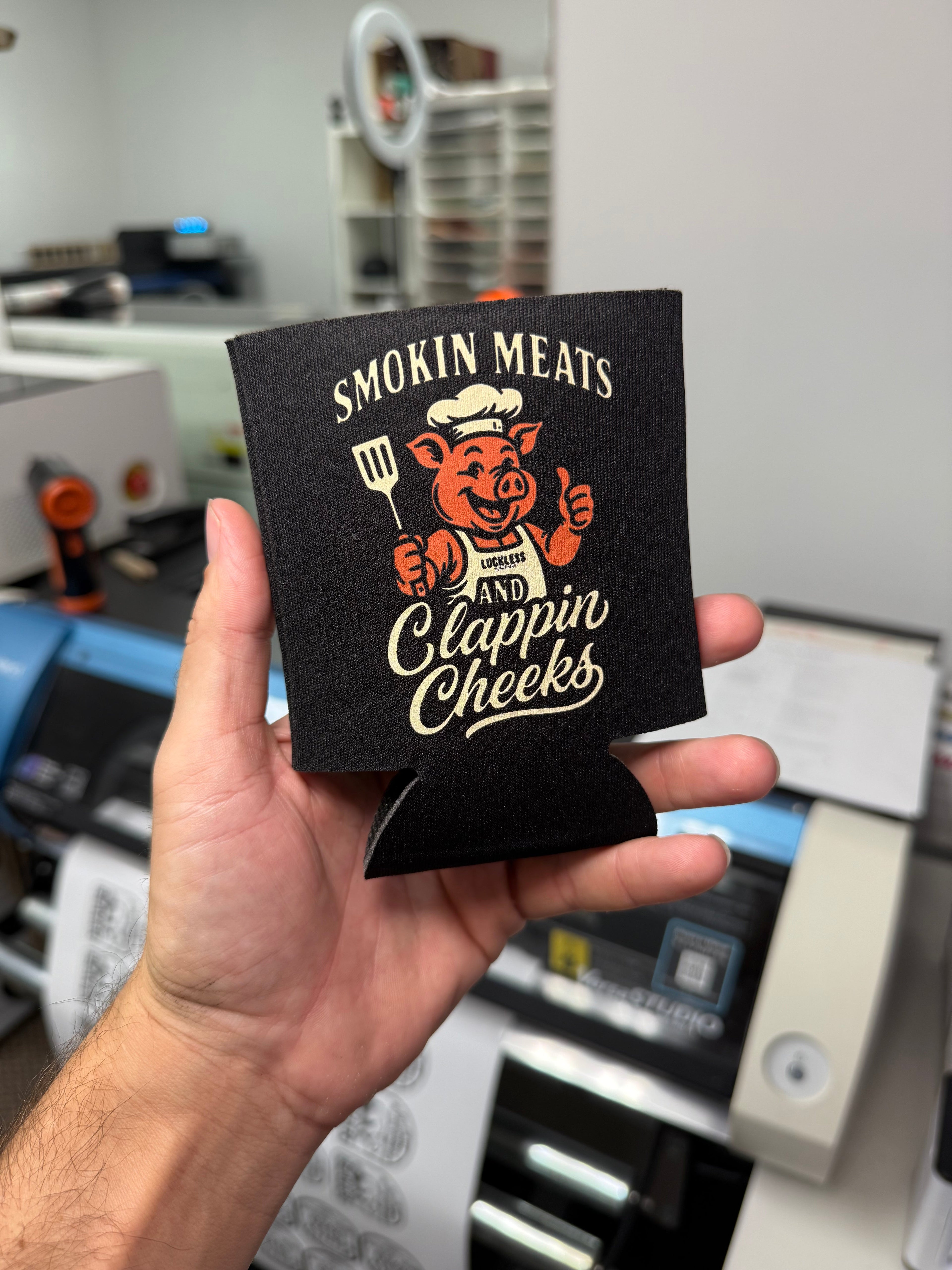 Luckless Outfitters Smokin Meats and Clappin Cheeks Koozie — detail close-up