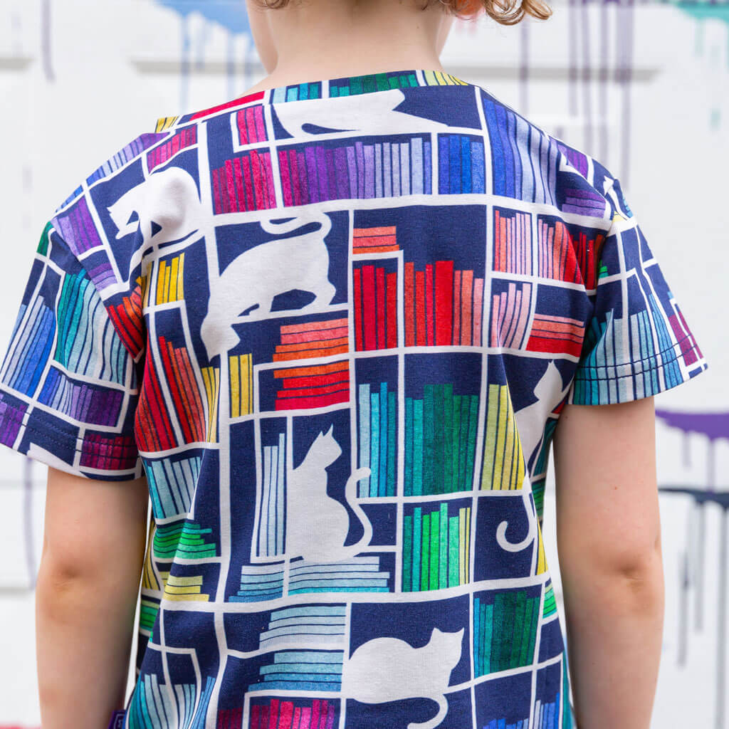 Princess Awesome & Boy Wonder "Check Meowt" Rainbow Books & Cats Henley Short Sleeve Tee — Princess Awesome & Boy Wonder branding close-up