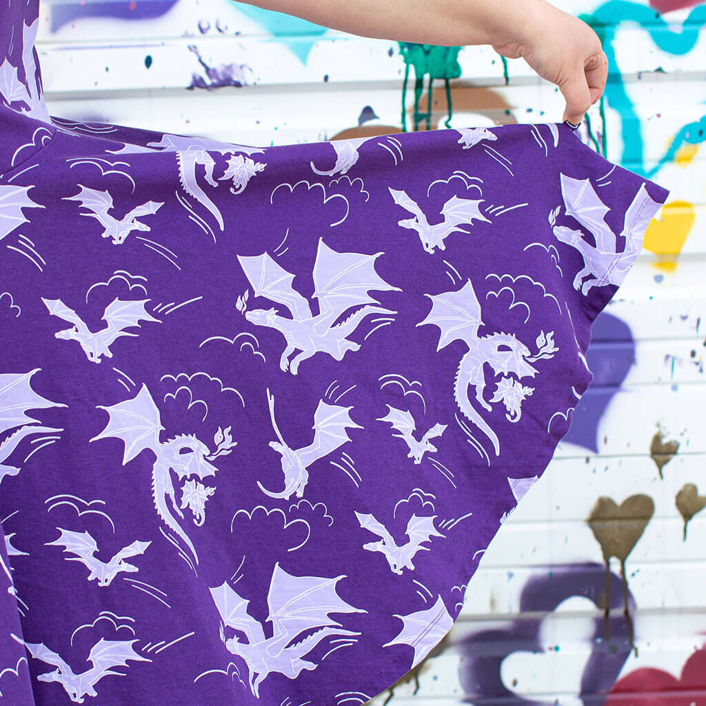 Princess Awesome & Boy Wonder Adult "Purple Reign" Dragons Short Sleeve Super Twirler Dress with Pockets — Princess Awesome & Boy Wonder branding close-up