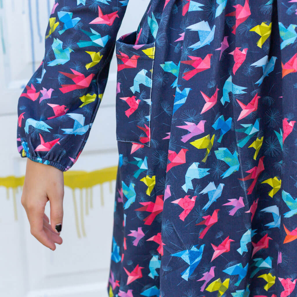 Princess Awesome & Boy Wonder "Flight of Fancy" Origami Birds Long Sleeve Dress with Patch Pockets — Princess Awesome & Boy Wonder branding close-up