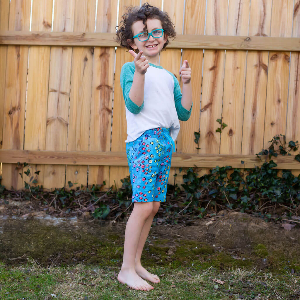 Princess Awesome & Boy Wonder "Summer School" Rainbows of Fish Drawstring Shorts with Pockets — Princess Awesome & Boy Wonder branding close-up