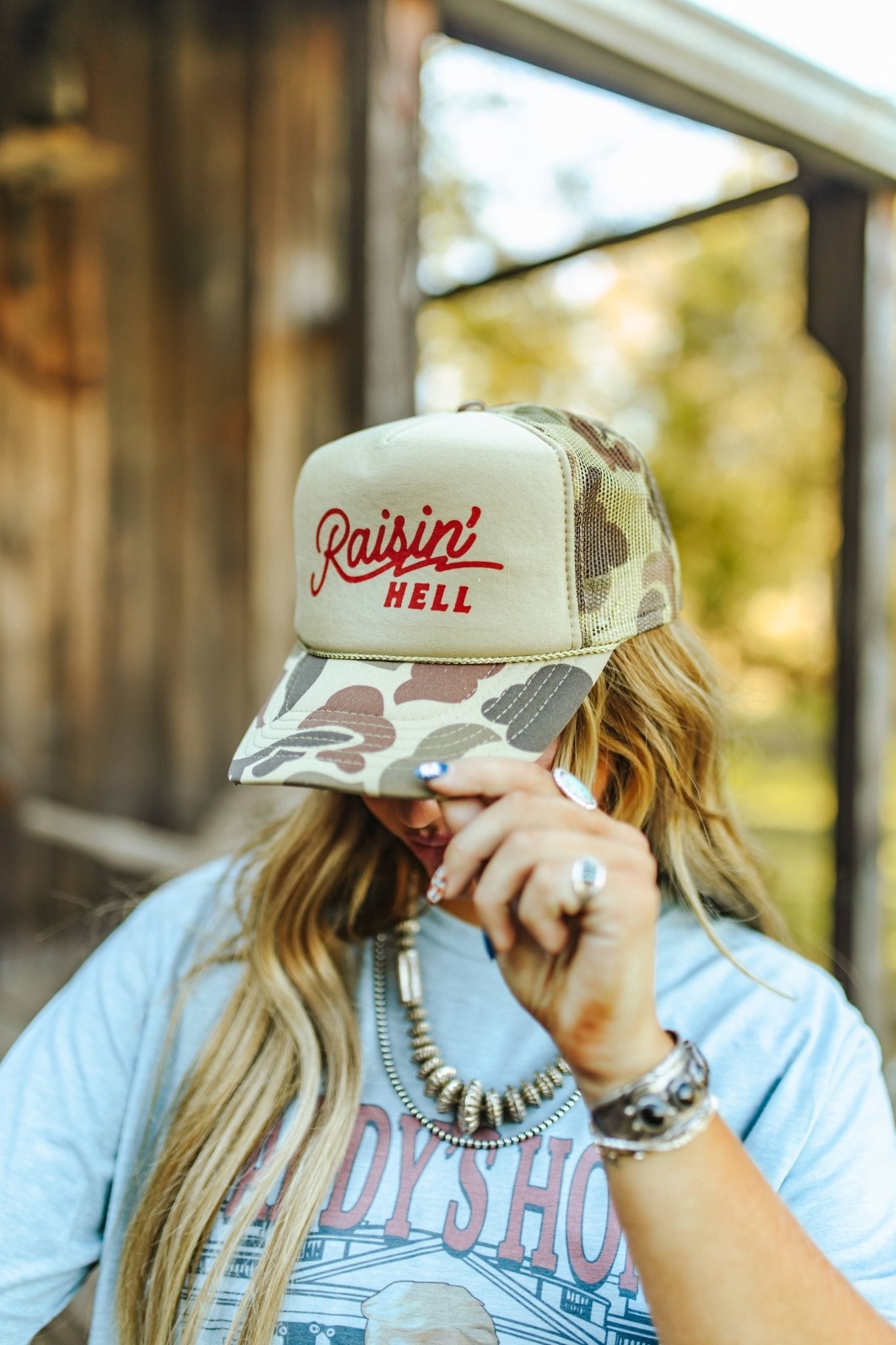 Wild Junkie Raisin' Hell Green Camo Trucker Hat — detail close-up