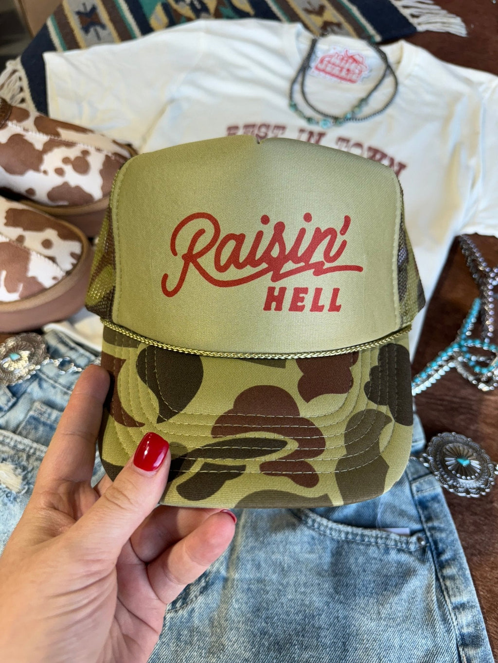 Wild Junkie Raisin' Hell Green Camo Trucker Hat — lifestyle context